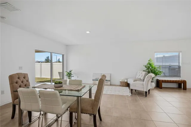 a dining room with furniture and potted plants