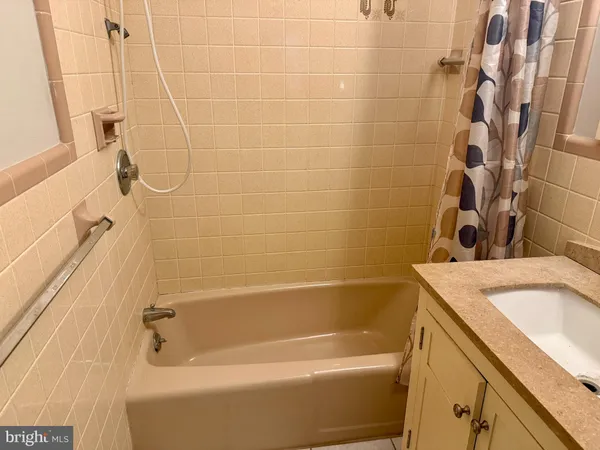 a bath tub sitting next to a white sink and vanity