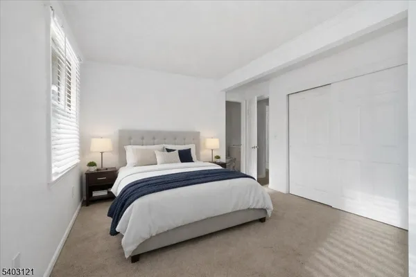 a bedroom with a bed lamp and a window