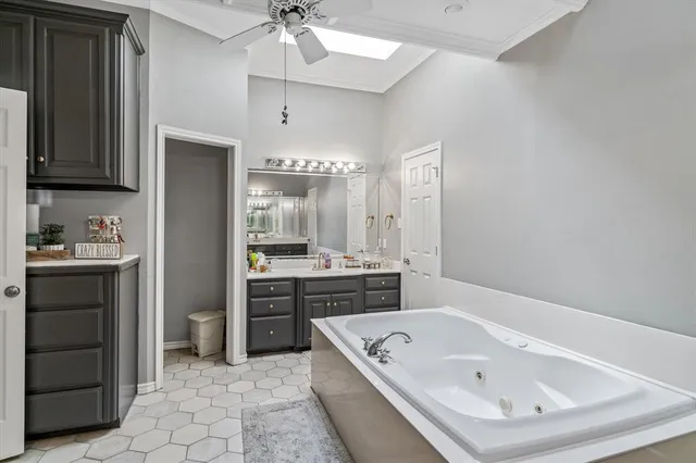 a bathroom with a tub a sink and a large mirror