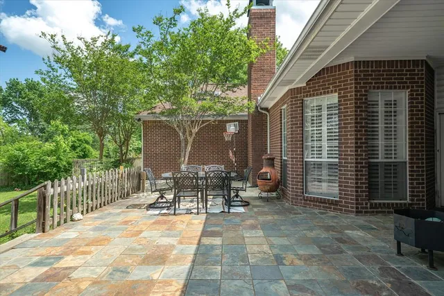 a view of a patio with table and chairs and wooden fence