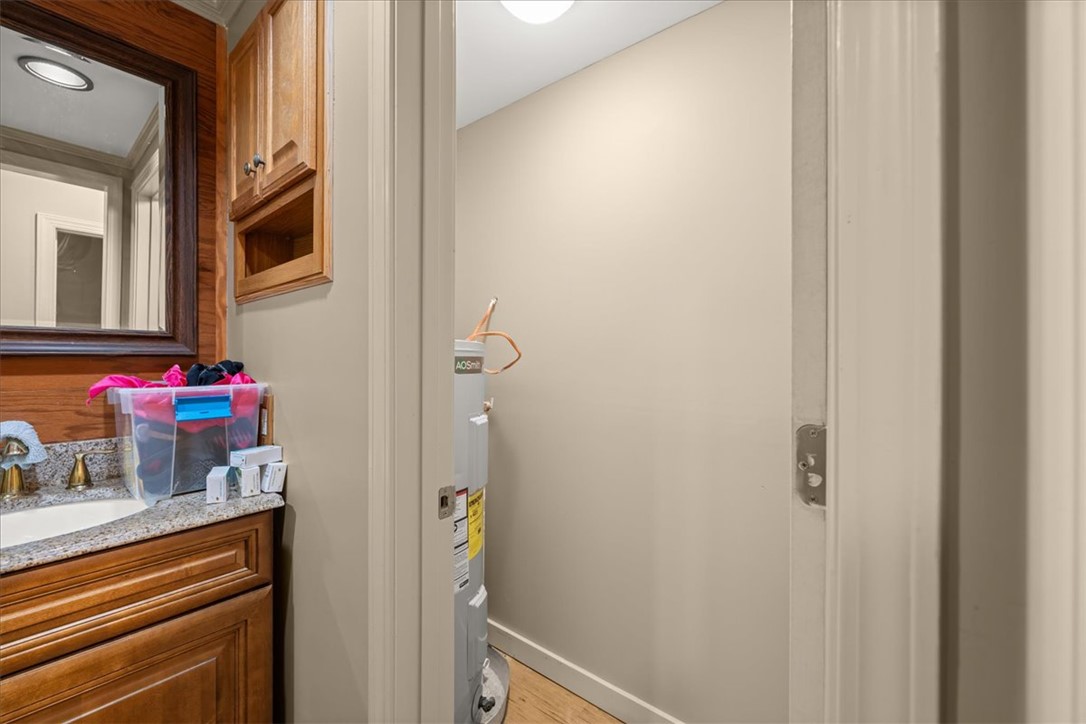 1102 West End Avenue Anderson, SC 29625 - Photo 22 of 28 Granite counters and wood cabinets frame a compact, organized laundry area.