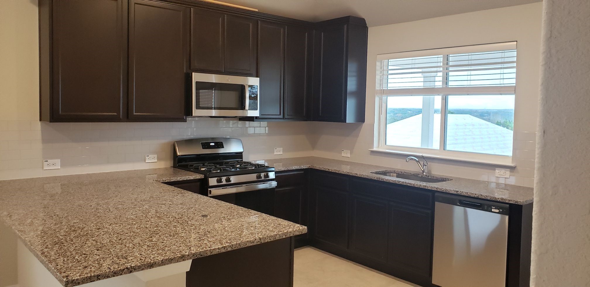 5612 Respinto Drive Austin, TX 78747 - Photo 9 of 23 a kitchen with a sink stove and microwave