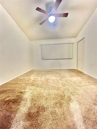 en empty room with ceiling fan and window