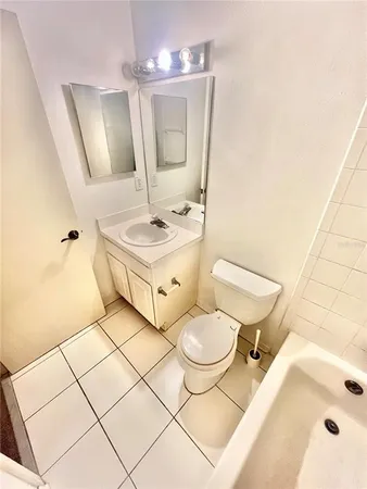 a bathroom with a sink toilet mirror and vanity
