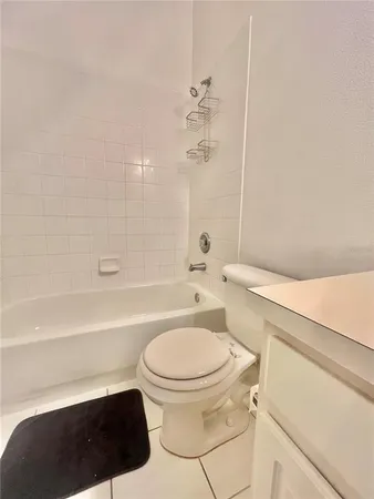 a bathroom with a bathtub shower sink vanity and toilet