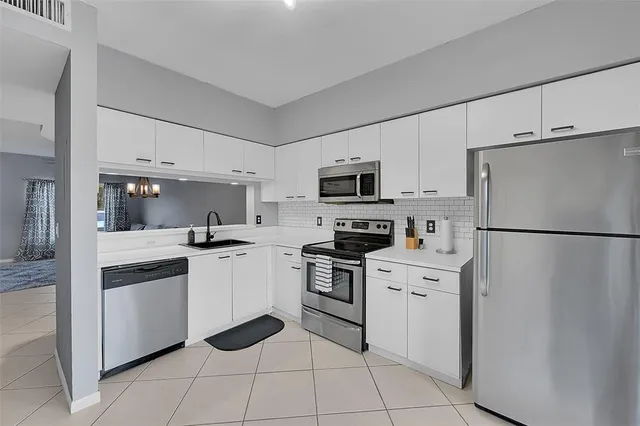 a kitchen with white cabinets and white appliances