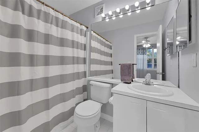 a bathroom with a sink toilet a mirror and shower curtain