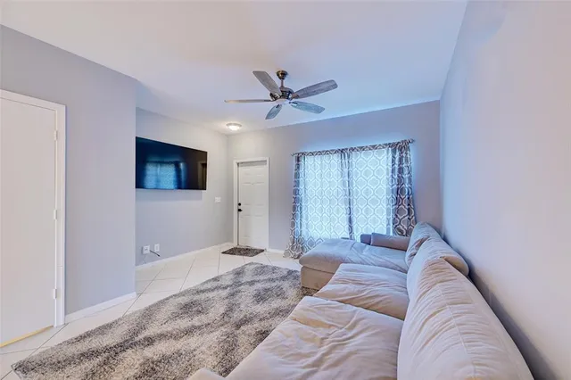 a living room with a couch and a ceiling fan
