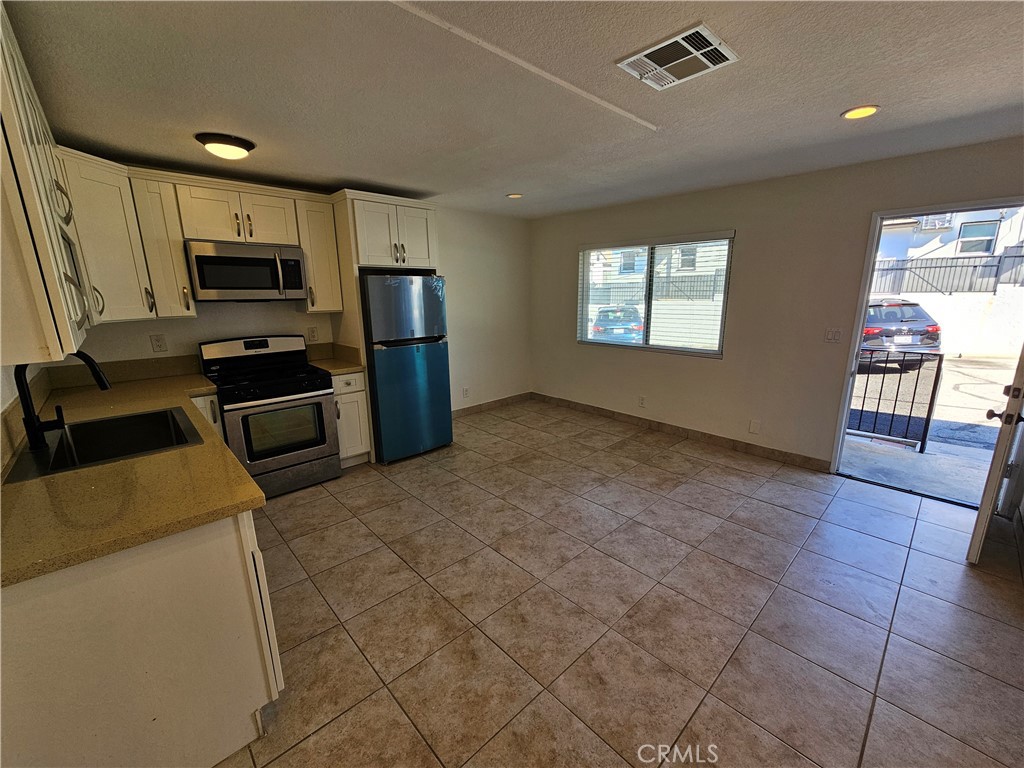 10037 Samoa Avenue, Unit 6 Tujunga, CA 91042 - Photo 7 of 7 a kitchen with stainless steel appliances granite countertop a refrigerator and a stove top oven
