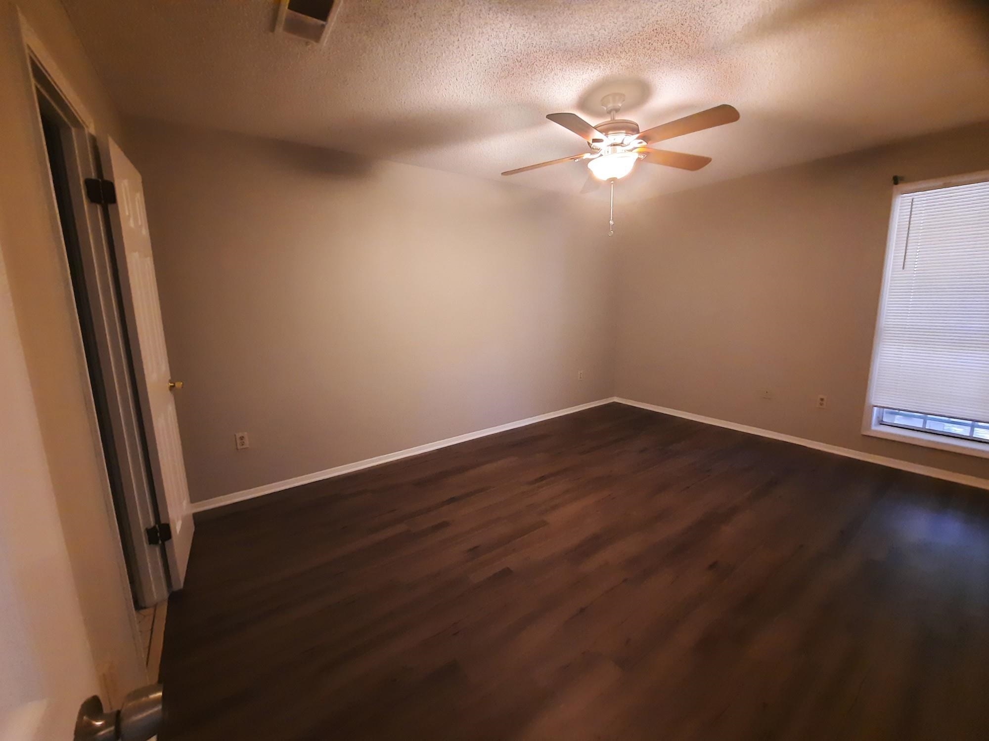 6991 Crestridge Road Memphis, TN 38119 - Photo 8 of 13 Unfurnished room with ceiling fan, dark hardwood / wood-style floors, and a textured ceiling