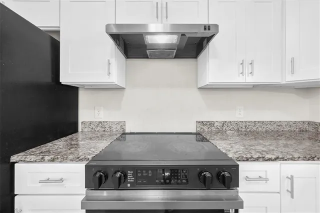 a stove top oven sitting inside of a kitchen