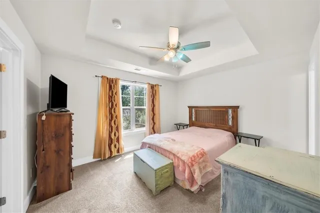 a bedroom with a bed and a flat tv screen on dresser