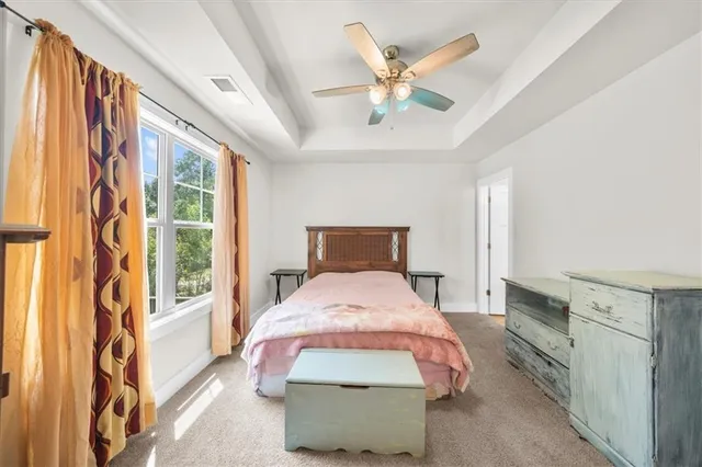 a bedroom with a large bed and a chandelier
