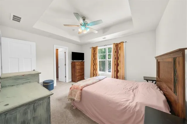 a bedroom with a bed and a flat tv screen on dresser