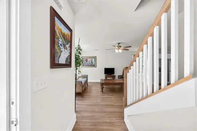 a view of a hallway with wooden floor and furniture