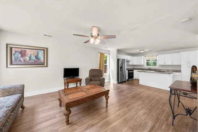 a living room with furniture a table and kitchen view