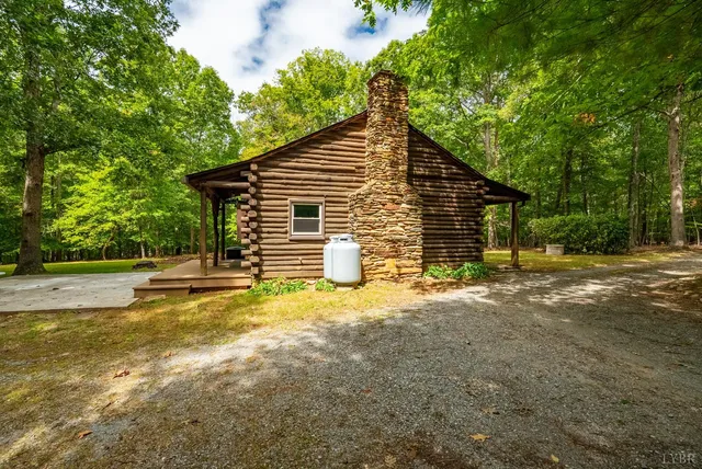 a view of a house with backyard and trees