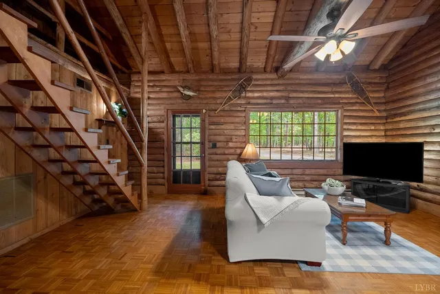 a living room with furniture floor to ceiling window and a flat screen tv