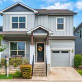 a front view of a house with glass windows and plants