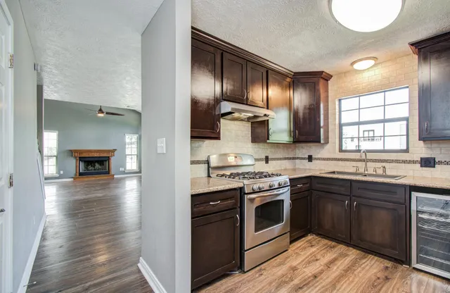 a kitchen with stainless steel appliances granite countertop a stove sink and cabinets