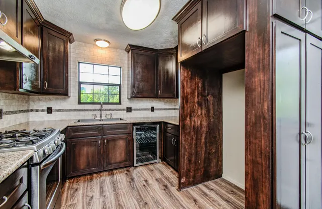 a kitchen with stainless steel appliances granite countertop a stove a sink and a refrigerator