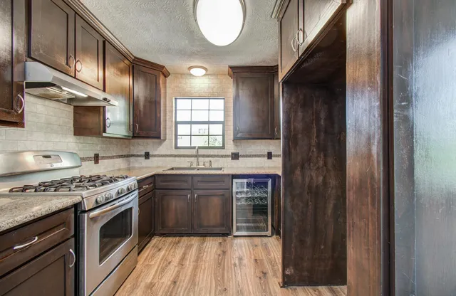 a kitchen with stainless steel appliances granite countertop a stove and a sink