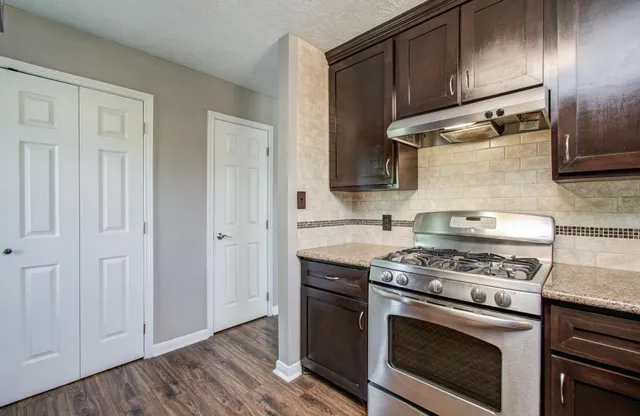 a kitchen with granite countertop wooden cabinets and stainless steel appliances