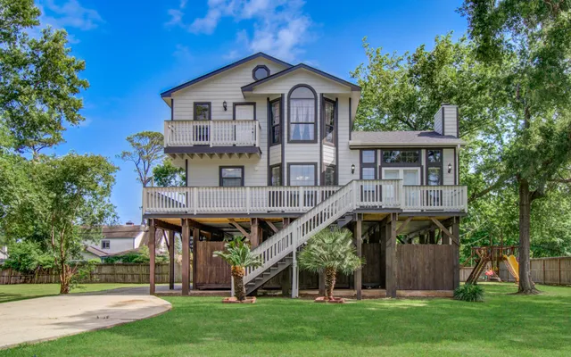 a view of a big house with a big yard and large trees