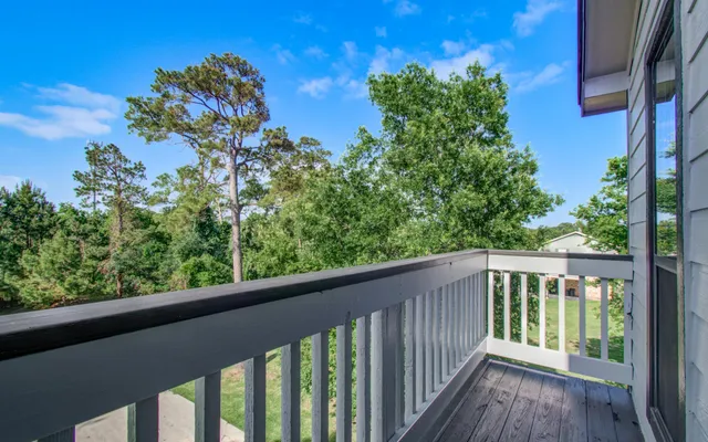 a balcony with wooden floor and fence