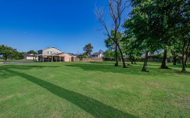 a view of green field with trees in the background