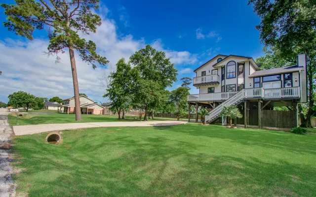 a view of a house with a yard and potted plants