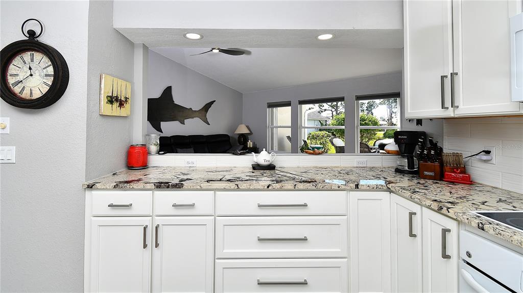 5010 Sable Key Circle Punta Gorda, FL 33955 - Photo 15 of 41 a kitchen with kitchen island granite countertop a stove a sink and a white cabinets