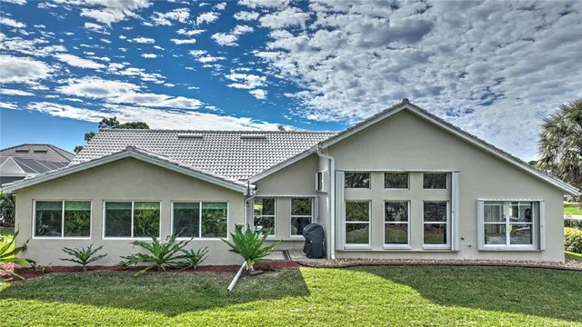 a front view of a house with a yard and potted plants