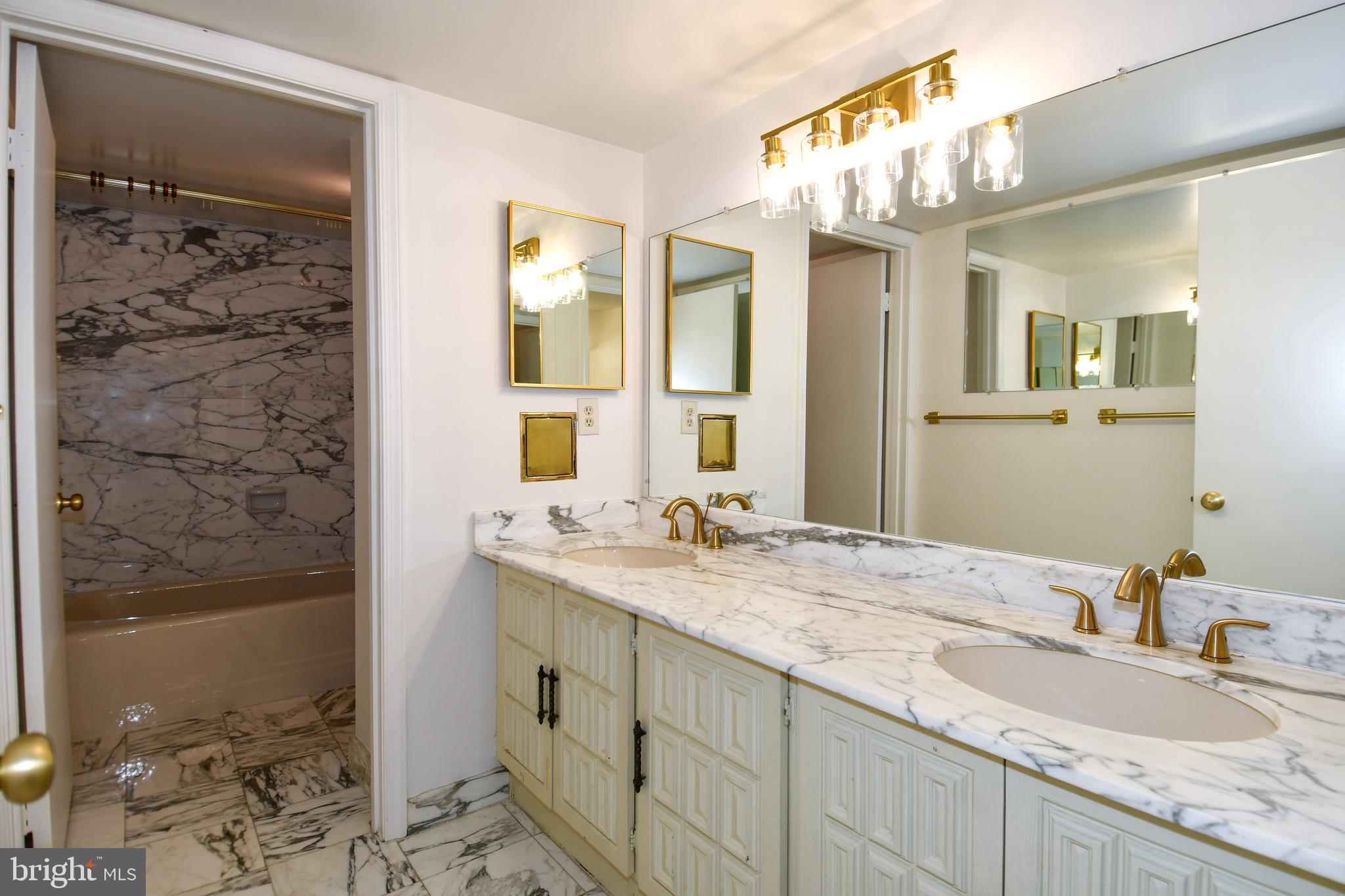 1101 South Arlington Ridge Road, Unit 316 Arlington, VA 22202 - Photo 36 of 75 a bathroom with a granite countertop sink a mirror and a shower