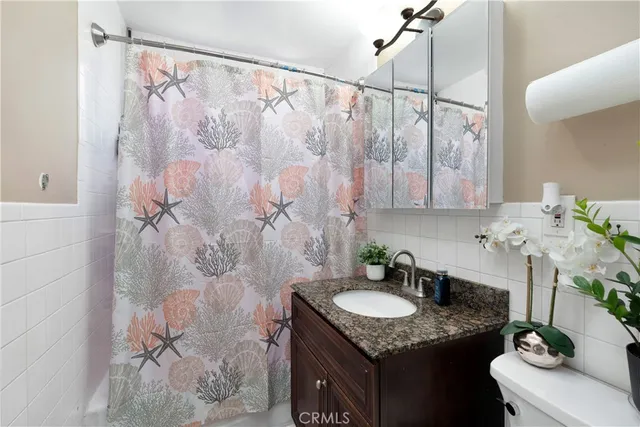 a bathroom with a granite countertop sink a mirror and shower
