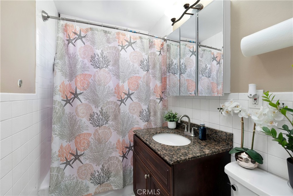 4712 West 152nd Street Lawndale, CA 90260 - Photo 8 of 21 a bathroom with a granite countertop sink a mirror and shower