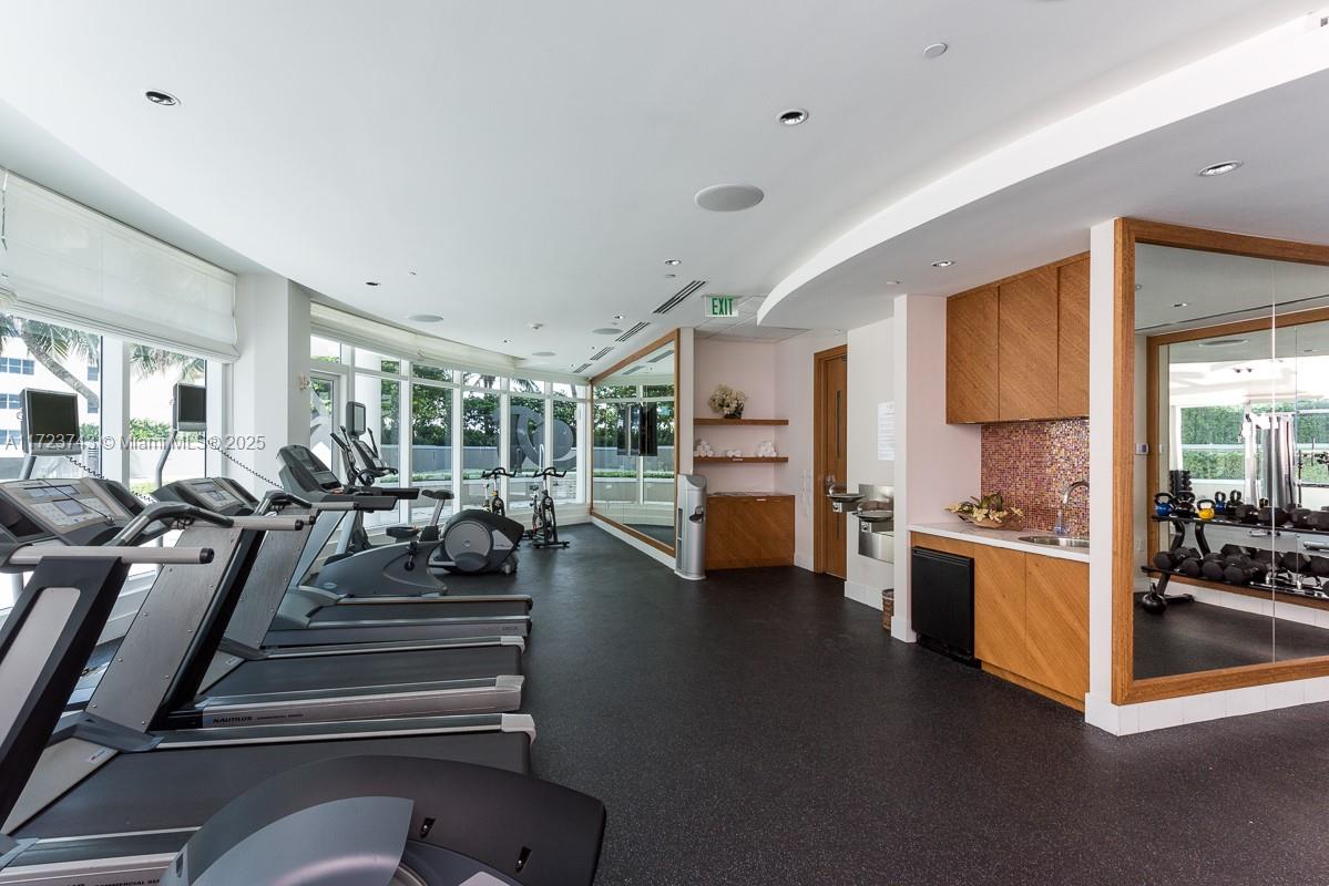 3801 Collins Avenue, Unit TH4 Miami Beach, FL 33140 - Photo 15 of 19 a gym room with lots of wooden furniture and a large window