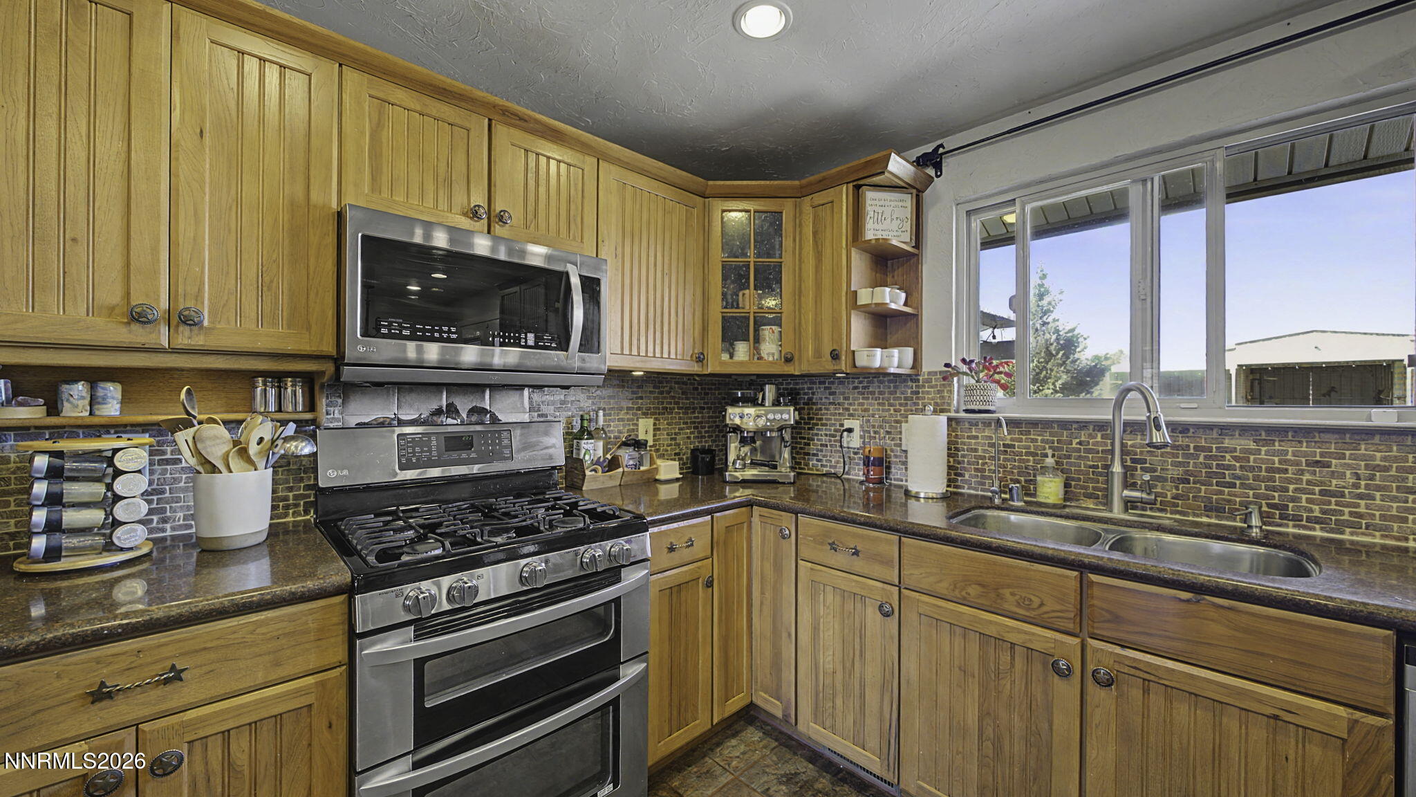 10585 Silver Knolls Boulevard Reno, NV 89508 - Photo 11 of 50 a kitchen with stainless steel appliances wooden cabinets and a stove top oven