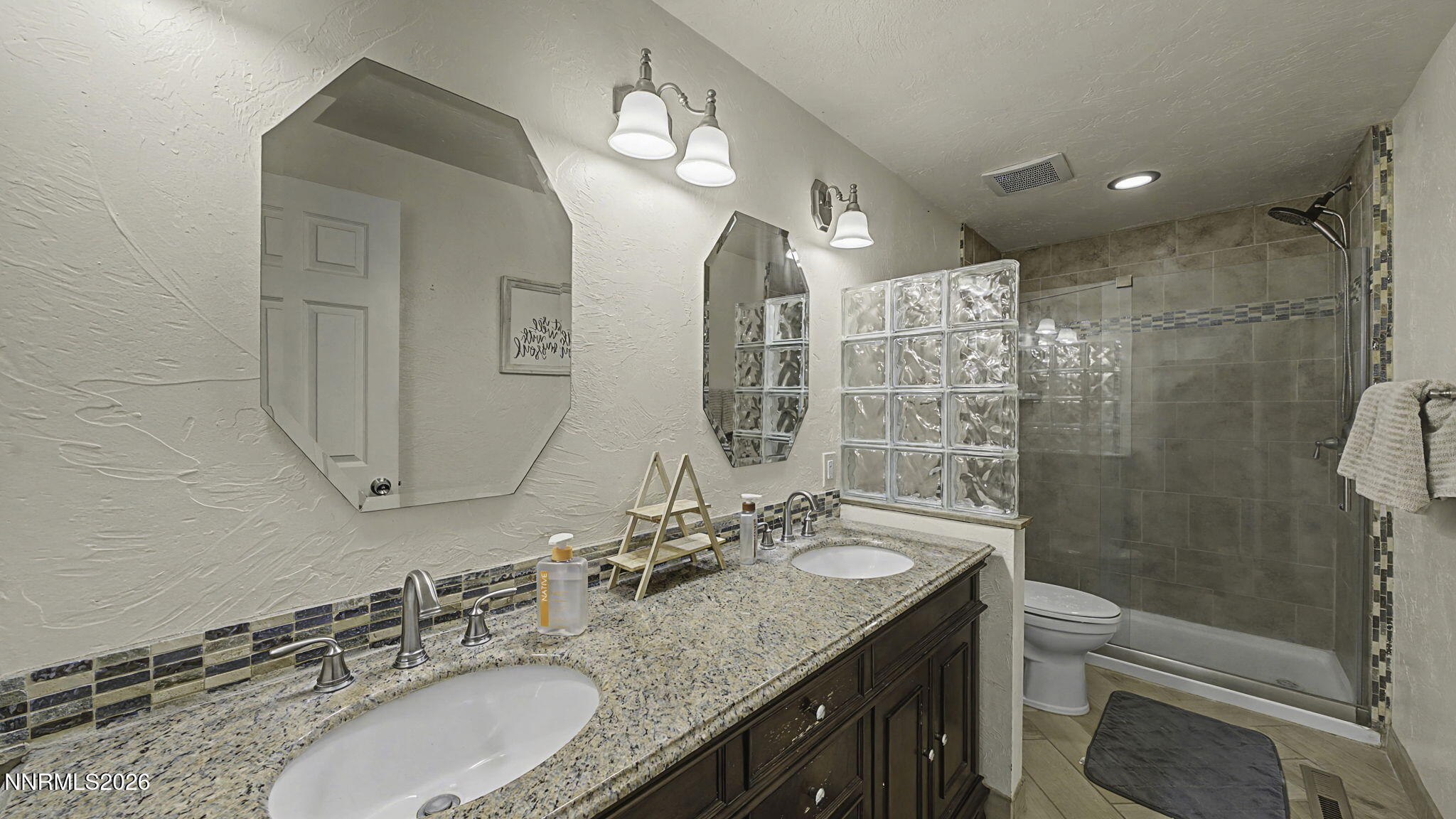 10585 Silver Knolls Boulevard Reno, NV 89508 - Photo 22 of 50 a bathroom with a granite countertop double vanity sink toilet and shower