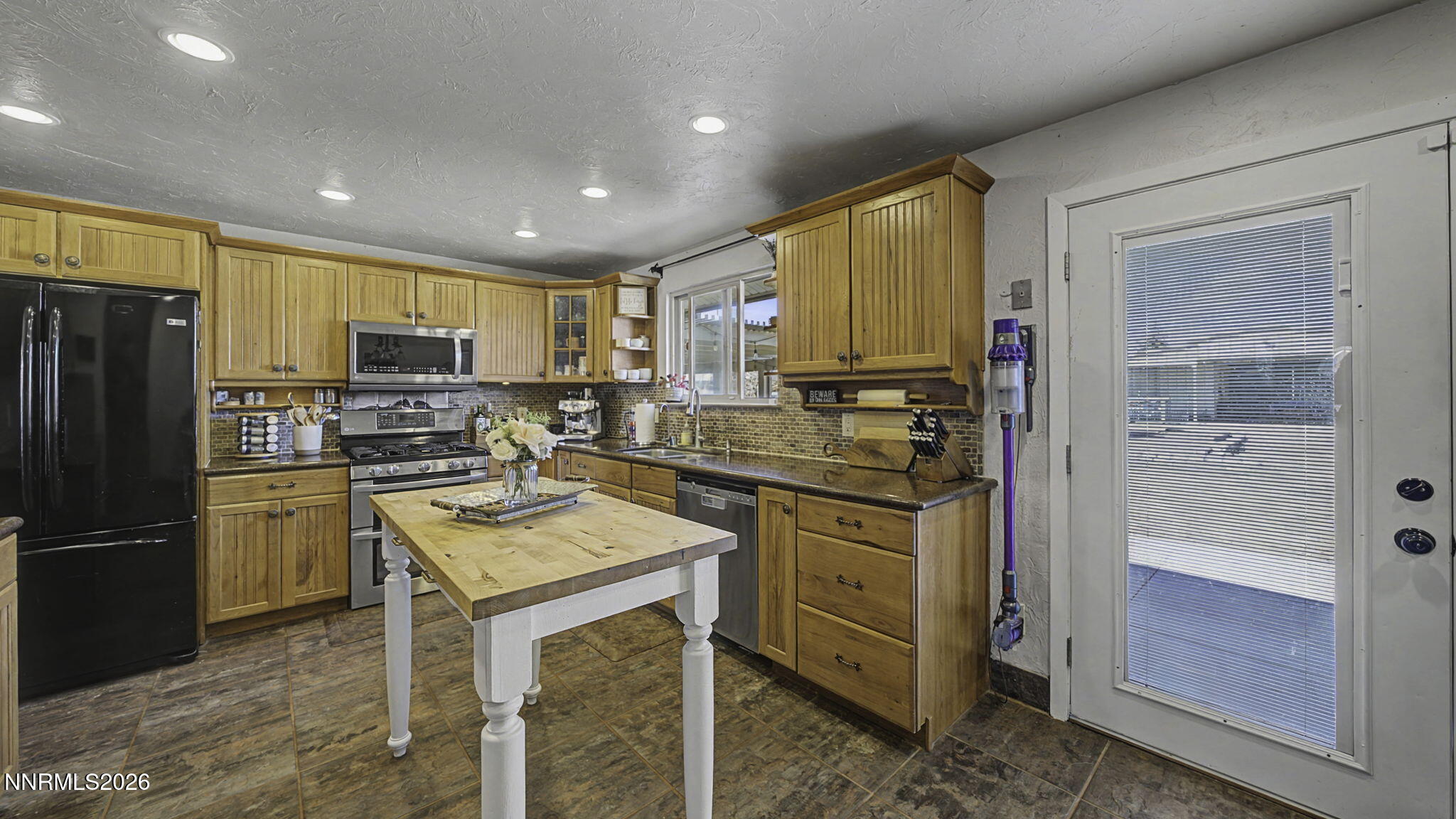 10585 Silver Knolls Boulevard Reno, NV 89508 - Photo 9 of 50 a kitchen with kitchen island granite countertop stainless steel appliances a stove refrigerator sink and cabinets