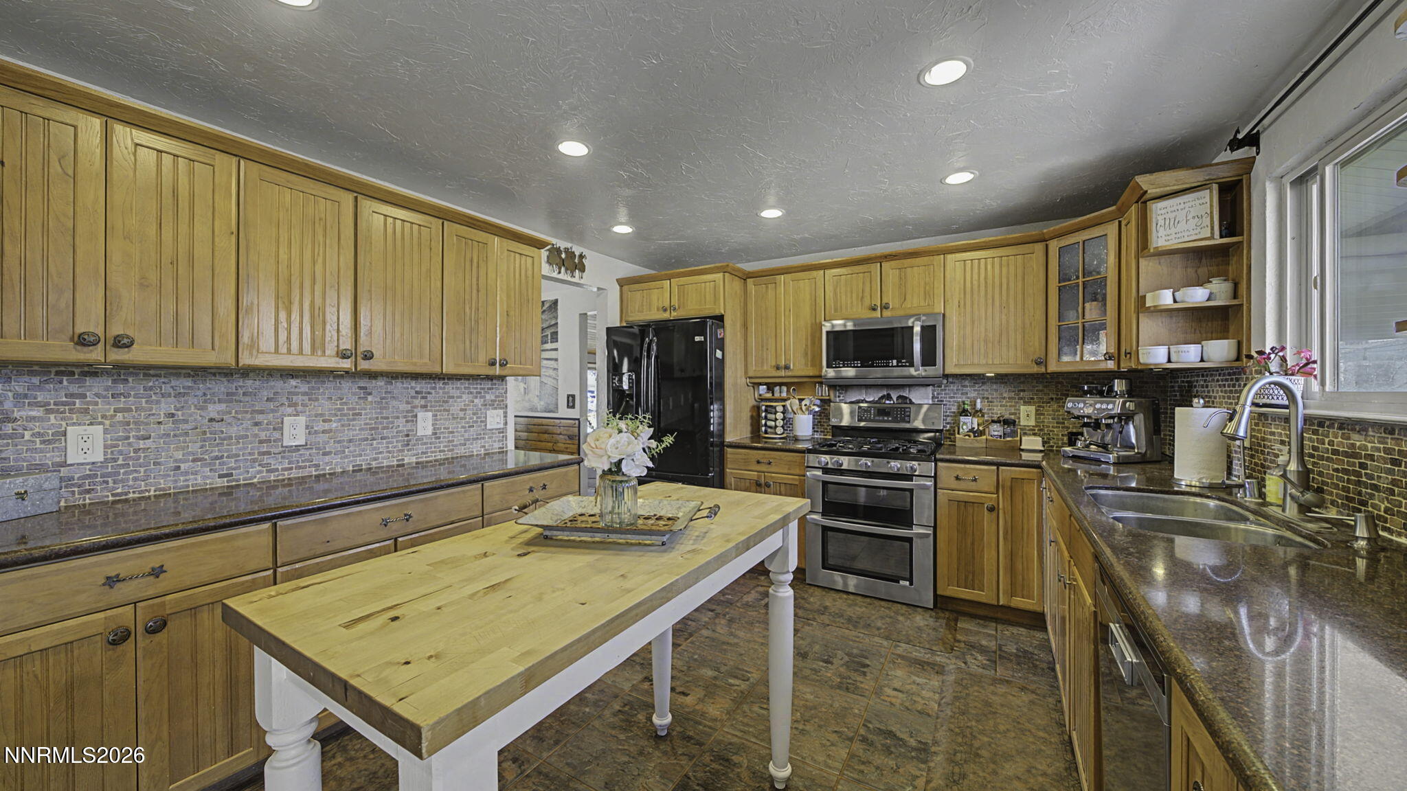 10585 Silver Knolls Boulevard Reno, NV 89508 - Photo 10 of 50 a kitchen with a sink stainless steel appliances wooden floor and a counter top space