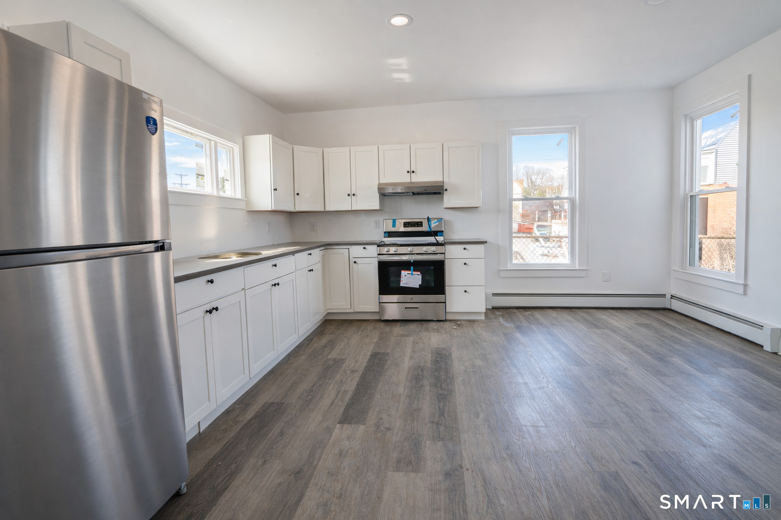 17 Sherman Avenue, Unit 3 Meriden, CT 06450 - Photo 3 of 19 a kitchen with stainless steel appliances granite countertop a refrigerator a sink dishwasher a stove and white countertops with wooden floor