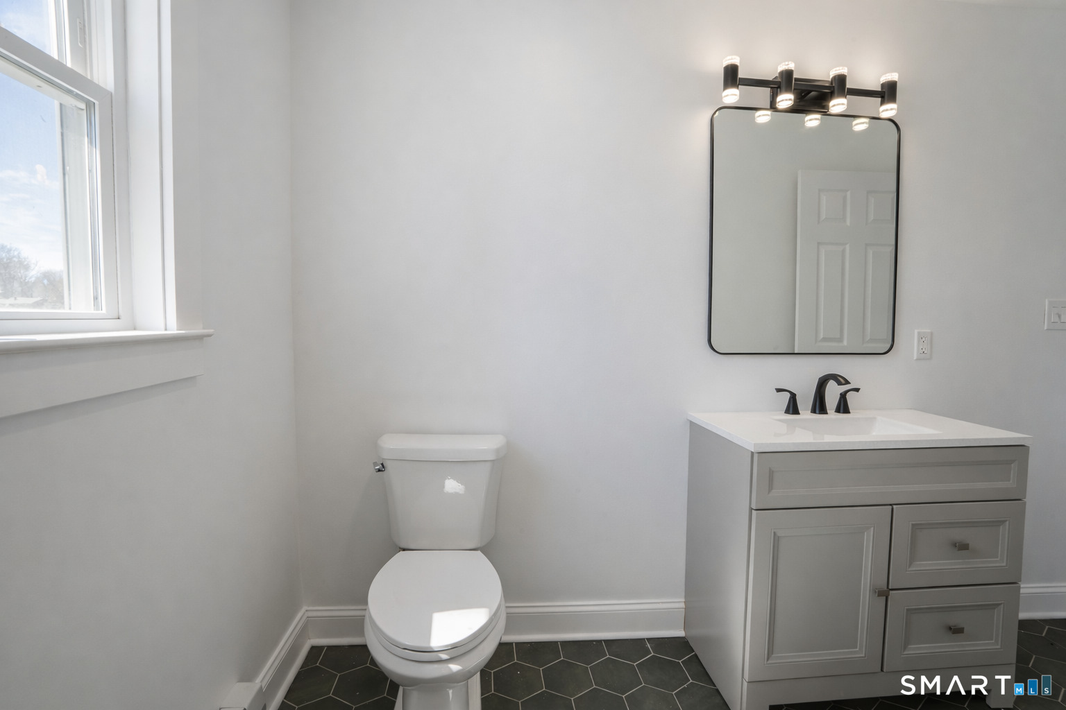 17 Sherman Avenue, Unit 3 Meriden, CT 06450 - Photo 10 of 19 a bathroom with a toilet a sink a vanity and mirror