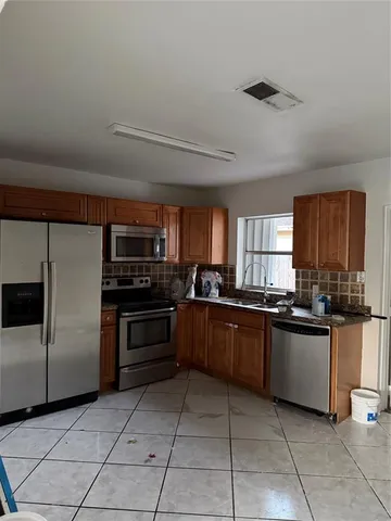 a kitchen with stainless steel appliances granite countertop a stove and a refrigerator