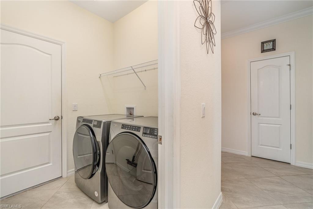 2276 Dancy Street Naples, FL 34120 - Photo 31 of 47 Laundry room featuring washer and dryer, light tile patterned floors, and crown molding