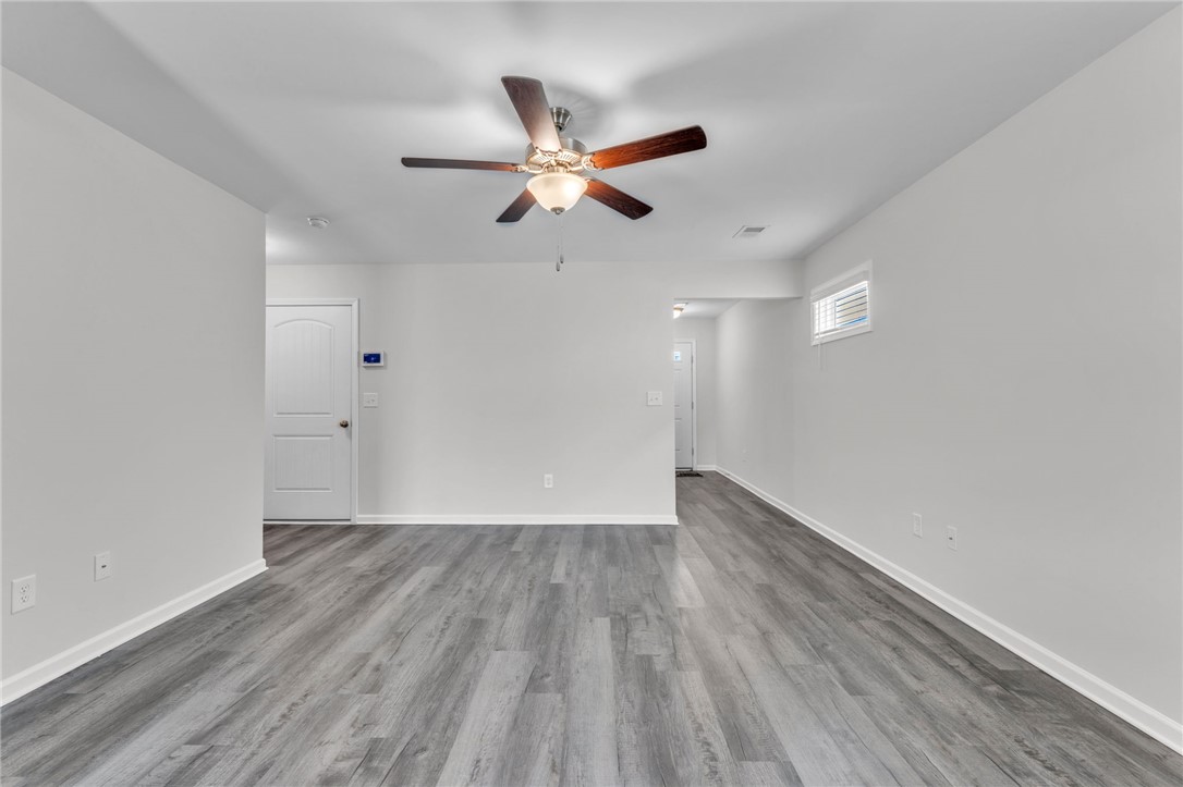 208 Samuel Street Pendleton, SC 29670 - Photo 4 of 32 A well-lit living area showcases durable vinyl plank flooring and a functional ceiling fan.