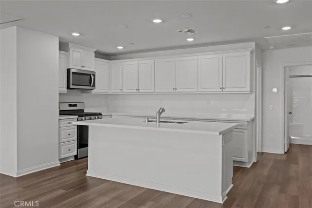 a kitchen with stainless steel appliances granite countertop a stove a sink and a refrigerator