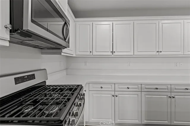 a kitchen with white cabinets and appliances