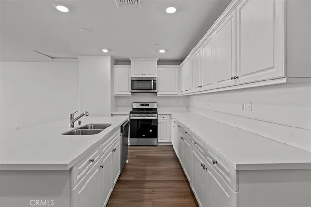 a kitchen with stainless steel appliances a sink stove and cabinets
